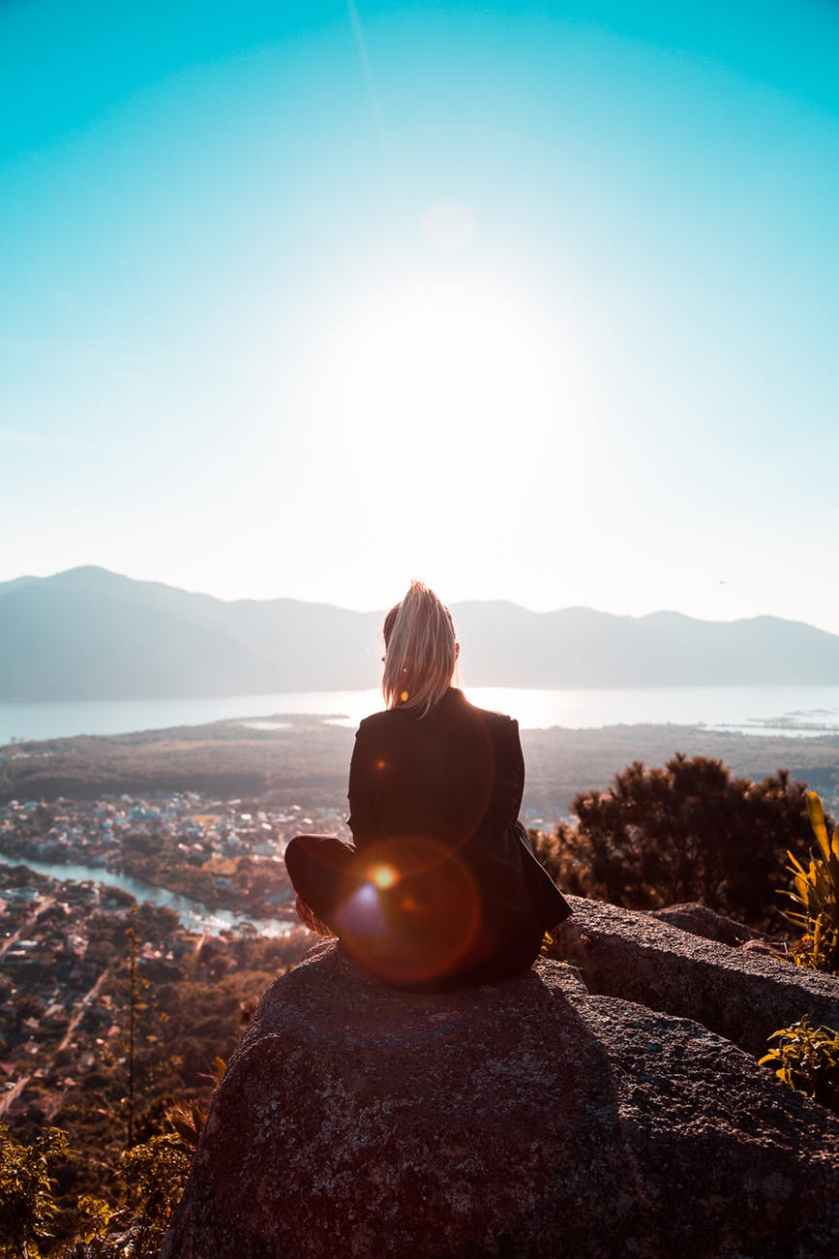 woman sitting on rock